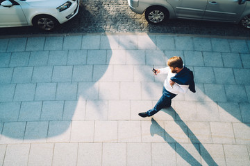 Man in suit walking in city and using phone