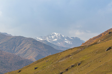 Green mountainside  on a background of snow-capped peaks in Svaneti in the mountainous part of Georgia