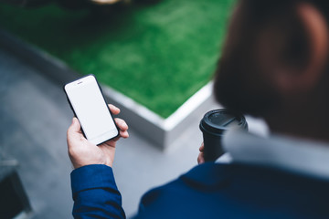 Crop modern businessman texting on smartphone