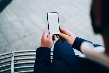 Man working by hand holding smartphone outside