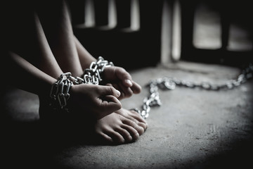Hopeless man hands tied together with chain, Victims of human trafficking