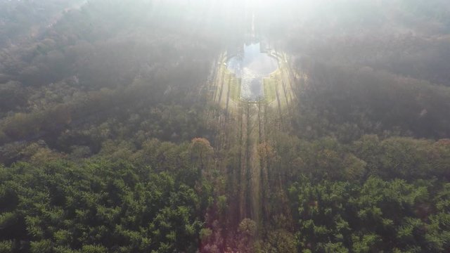 Flying towards beautiful pond in forest against a low winter sun