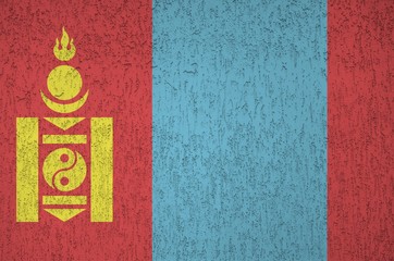 Mongolia flag depicted in bright paint colors on old relief plastering wall. Textured banner on...