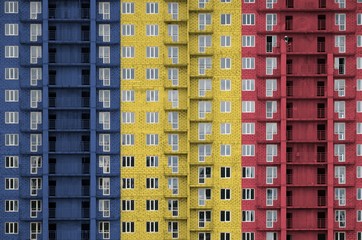 Romania flag depicted in paint colors on multi-storey residental building under construction....