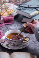 A person stirring of the tea with  a spoon 