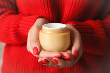 Woman holding jar of moisturizing cream, closeup. Winter cosmetic. Space for text