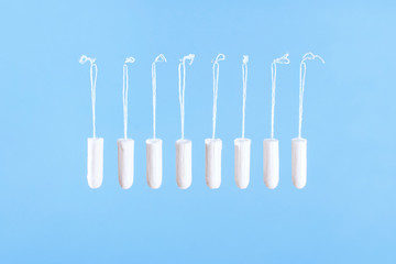 Flying tampons. Menstrual period concept. Woman hygiene protection. Women's health. Cotton tampons on blue background. Front view. Conceptual minimal still life.