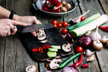 Female hands cut vegetables on the board. Cooking vegetarian food.