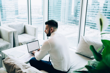 Businessman working with laptop in business center lounge