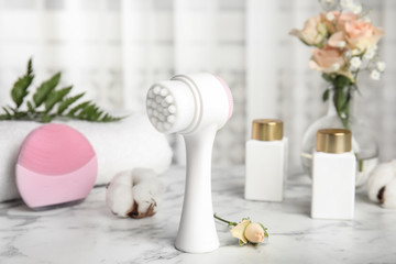 Fototapeta na wymiar Modern face cleansing brush on marble table. Cosmetic accessory