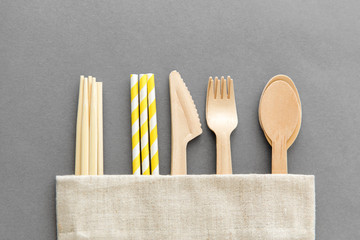 recycling and eco friendly concept - wooden disposable spoons, forks, knives, chopsticks and paper...