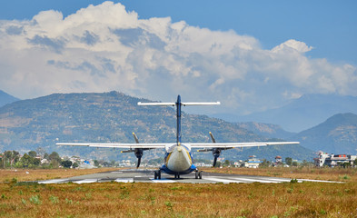  A plane of local, Nepalese airlines on the runway of the airport in Pokhara is preparing for take-off.