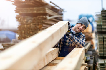 Young male worker in timber warehouse 