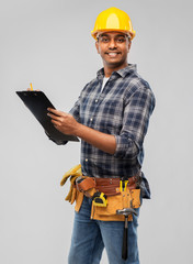 profession, construction and building - thinking indian worker or builder in helmet with clipboard and pencil over grey background