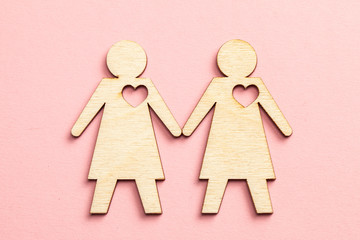 Two lesbian women couple holding hands on pink background