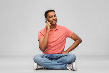technology, communication and people concept - happy indian man calling on smartphone over grey background