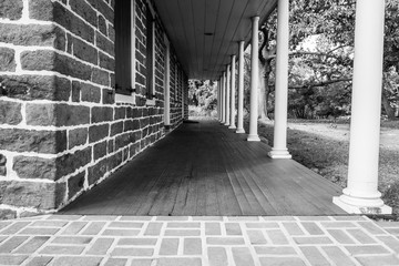 Stone wall building exterior with covered porch. 