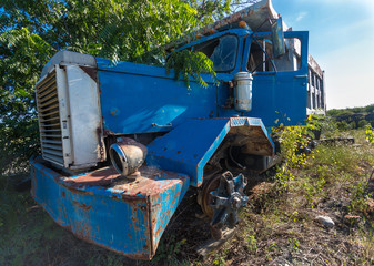 dramatic angle of brocken down truck old and abandoned, overgrown and rusted in the caribbean,