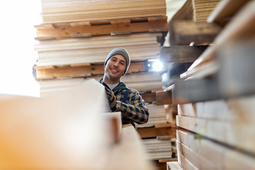 Young male worker in timber warehouse 