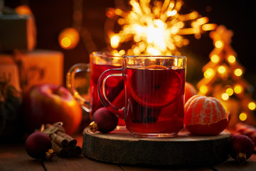Two glasses of hot fruit tea on christmas table in soft-focus in the background