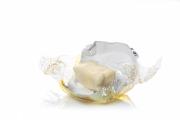 white chocolate candy on its open wrap isolated on white background with copy space for your text