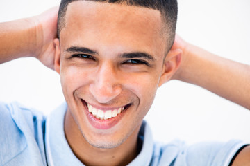 Obraz premium Smiling North African man relaxing with hands behind head against white background
