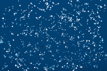 Silver stars scattering on blue background.