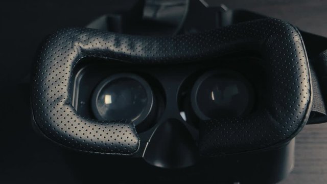 Close-up of virtual reality glasses VR hemlet lying on black table. Modern technologies concept.