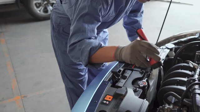 Mechanic man examining and maintenance to customer the engine a vehicle car hood, Safety inspection test engine, transportation repair service center,  4K UHD cinematic footage