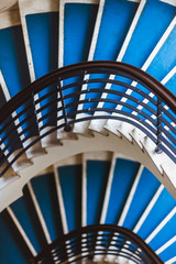 Blue background made for Old blue spiral staircase inside an old house. Color 2020.