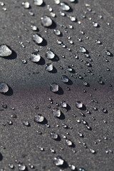 Fototapeta na wymiar rain drops on black surface