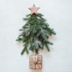 Christmas tree made of natural fir branches with wooden star and paper gift. Zero Waste Christmas concept