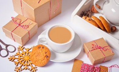 Cup of tea, homemade cookie, Christmas gift boxes and Christmas decor on the white background.
