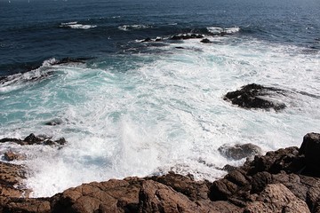 Movement on the shore. A view of sea waves bursting on the rocks and forming foam in Algarrobo beach in Chile