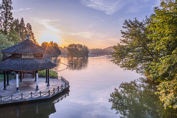 Fototapeta premium A pavilion during sunrise in West Lake in Hangzhou, Zhejiang province，China with all Chinese words on it only introduces itself which means