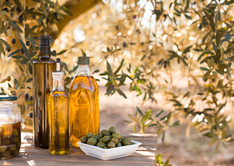 green olives and oil on table in olive grove