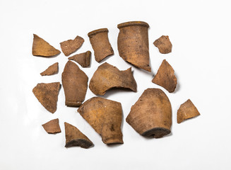 Shards of an ancient clay jar on a white background.