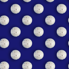 Seamless Christmas pattern with shiny white balls on blue background. Flat lay.