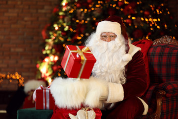 Obraz na płótnie Canvas Santa Claus with gift sack near Christmas tree indoors