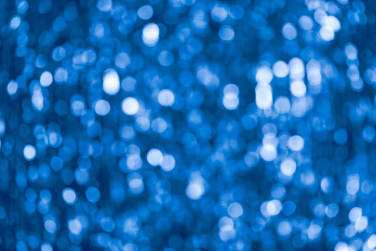 Blue abstract shimmering bokeh background with shining lights, macro image of sequin cloth