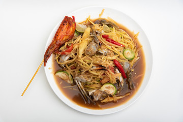 Papaya Salad with Salted Crab and Fermented Fish, served with grilled chicken wings on white background.