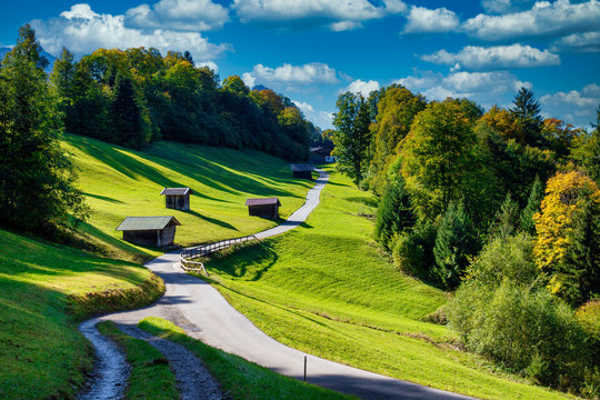Alpenstra&szlig;e mit kleinen H&uuml;tten unter blauen Himmel