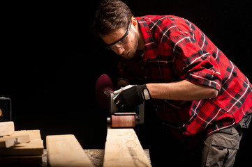 Carpenter works with electrical planer