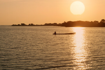Naklejka na ściany i meble Asian fishermen on boat in the morning sun background