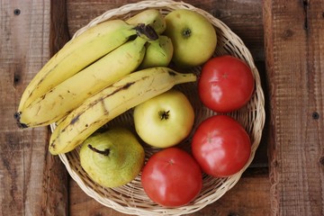 Fruits and vegetables in a wooden basket on the table