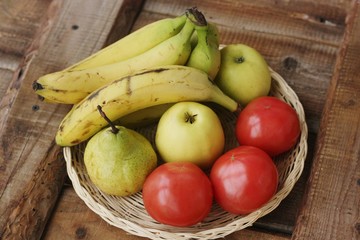 Fruits and vegetables in a wooden basket on the table