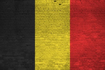 Belgium flag depicted in paint colors on old brick wall. Textured banner on big brick wall masonry...