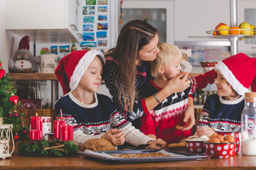 Happy children, boy brothers and mother, baking christmas cookies at home
