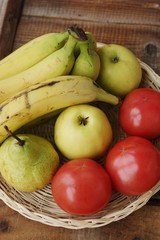 Fruits and vegetables in a wooden basket on the table