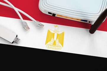 Egypt flag depicted on table with internet rj45 cable, wireless usb wifi adapter and router....